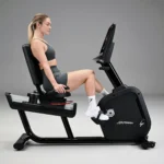 Home cardio bike with wide pedals, front assist handle, and LED display