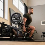 Plate-loaded lower body machine with angled handles and single-leg squat pad