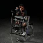 Seated arm curl machine with large elbow pad and plate-loaded resistance